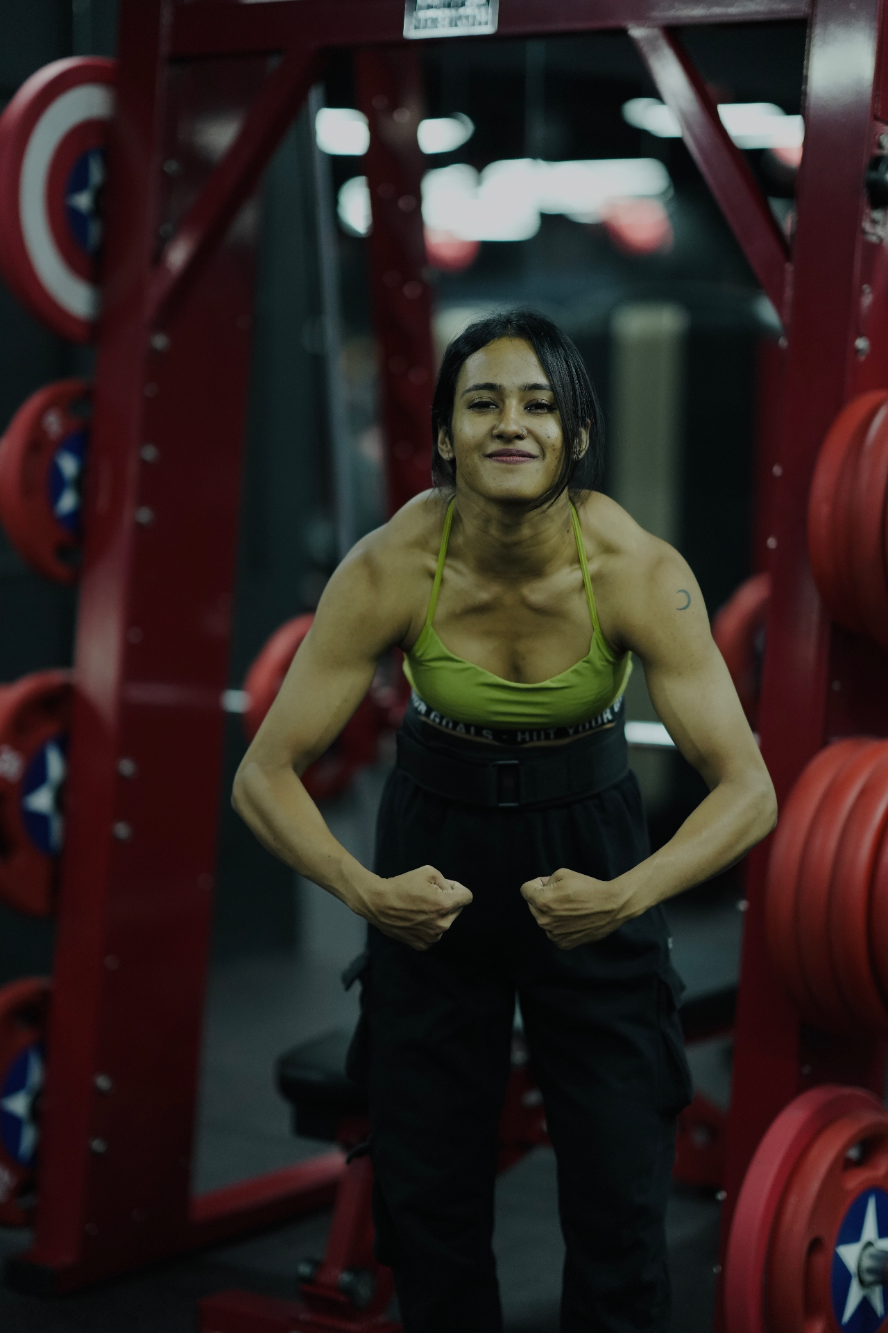 Aswathy flexing at the squat rack